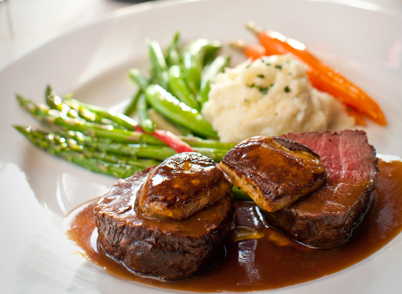 Filet of beef and foie gras with baby carrots in a black truffle sauce at <i>Piñons</i> - © Hal Williams