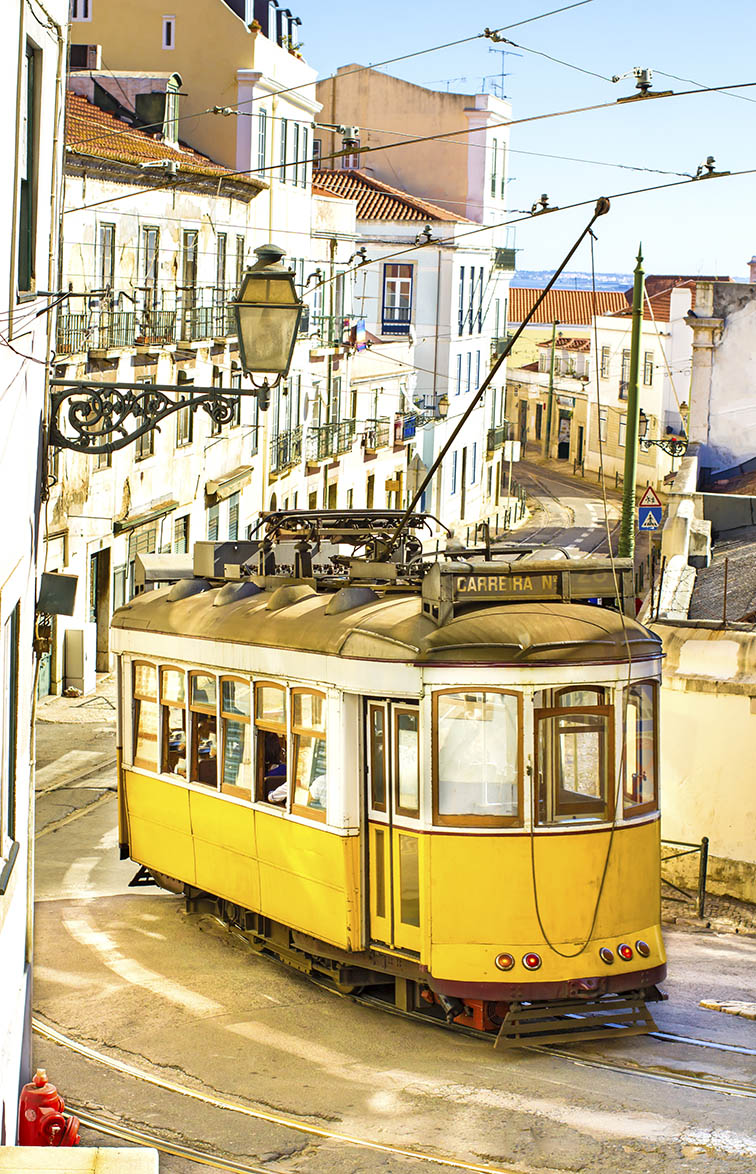 Wooden trolley car navigating the streets of the Alfama district.