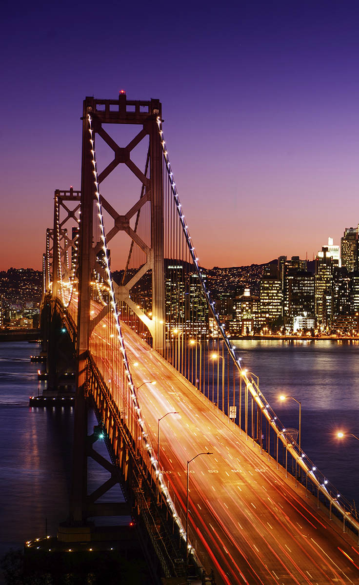 The San Francisco skyline and Bay Bridge at sunset.